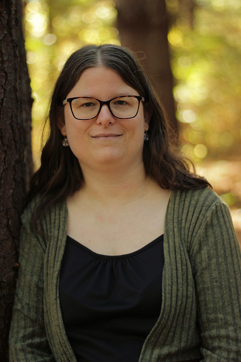 Kristen James, proofreader and scopist, outdoors in a wooded setting